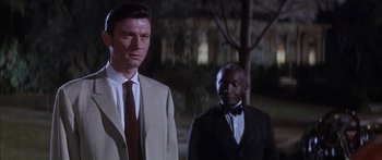 Movie still from “Summer and Smoke” (1961), directed by Peter Glenville – A man in a suit standing next to another man in a suit; Medium shot, Low angle