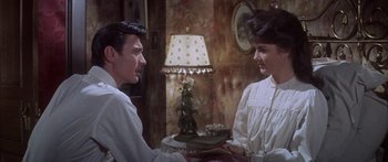 Movie still from “Summer and Smoke” (1961), directed by Peter Glenville – A man and a woman sitting at a table talking to each other; Medium shot, Over the shoulder angle