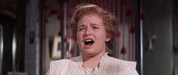 Movie still from “Summer and Smoke” (1961), directed by Peter Glenville – A woman is crying while standing in front of a curtain; Close Up shot, Low angle