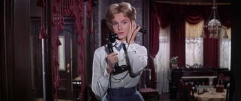 Movie still from “Summer and Smoke” (1961), directed by Peter Glenville – A woman holding a phone in her hands; Medium shot, Low angle