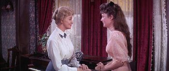 Movie still from “Summer and Smoke” (1961), directed by Peter Glenville – Two women are talking to each other in front of a piano; Medium shot, Over the shoulder angle