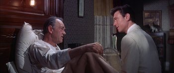 Movie still from “Summer and Smoke” (1961), directed by Peter Glenville – Two men sitting on a couch talking to each other; Medium shot, Over the shoulder angle