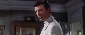 Movie still from “Summer and Smoke” (1961), directed by Peter Glenville – A person wearing a suit and tie; Close Up shot, Low angle