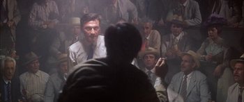 Movie still from “Summer and Smoke” (1961), directed by Peter Glenville – A group of men sitting in front of each other in a room; Medium shot, Over the shoulder angle