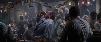 Movie still from “Summer and Smoke” (1961), directed by Peter Glenville – A man in a suit and tie drinking from a straw; Medium shot, Low angle