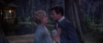 Movie still from “Summer and Smoke” (1961), directed by Peter Glenville – An older woman and a younger man in a forest; Medium shot, Over the shoulder angle