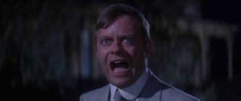 Movie still from “Summer and Smoke” (1961), directed by Peter Glenville – A man in a gray suit and white tie; Close Up shot, Low angle