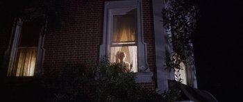 Movie still from “Summer and Smoke” (1961), directed by Peter Glenville – A person looking out of a window at night; Wide shot, Low angle