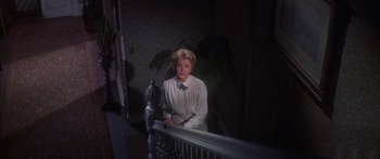Movie still from “Summer and Smoke” (1961), directed by Peter Glenville – A woman standing on the stairs of a house; Medium shot, Low angle