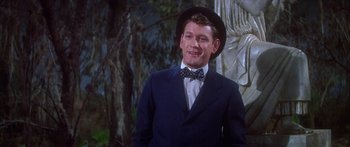 Movie still from “Summer and Smoke” (1961), directed by Peter Glenville – A man wearing a suit and bow tie and wearing a hat; Medium shot, Low angle