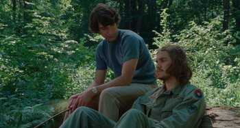 Movie still from “Taking Woodstock” (2009), directed by Ang Lee – Two men sitting in the woods , one is smoking a cigarette; Medium shot, Over the shoulder angle