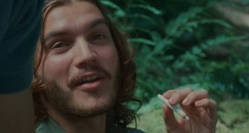 Movie still from “Taking Woodstock” (2009), directed by Ang Lee – A person holding a cigarette in his hand; Close Up shot, Low angle