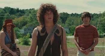 Movie still from “Taking Woodstock” (2009), directed by Ang Lee – A young man with long curly hair wearing a brown shirt; Medium shot, Over the shoulder angle