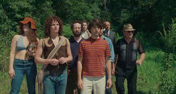 Movie still from “Taking Woodstock” (2009), directed by Ang Lee – A group of men standing in a line in the woods; Medium shot, Low angle