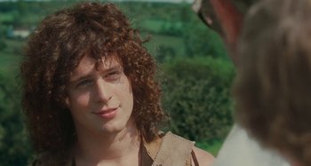 Movie still from “Taking Woodstock” (2009), directed by Ang Lee – A young man with long curly hair is smiling for the camera; Close Up shot, Over the shoulder angle