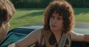 Movie still from “Taking Woodstock” (2009), directed by Ang Lee – A young man sitting in the back seat of a car; Close Up shot, Over the shoulder angle