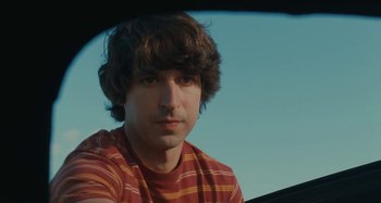 Movie still from “Taking Woodstock” (2009), directed by Ang Lee – A young man with brown hair wearing a striped shirt; Close Up shot, Low angle