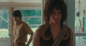 Movie still from “Taking Woodstock” (2009), directed by Ang Lee – A man with curly brown hair wearing a brown shirt; Medium shot, Over the shoulder angle
