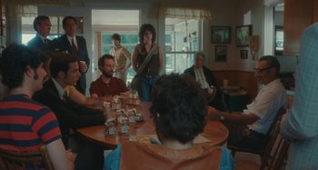 Movie still from “Taking Woodstock” (2009), directed by Ang Lee – A group of people sitting around a round table; Medium shot, Over the shoulder angle