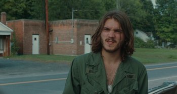Movie still from “Taking Woodstock” (2009), directed by Ang Lee – A man with long brown hair wearing a green jacket; Close Up shot, Over the shoulder angle