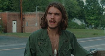 Movie still from “Taking Woodstock” (2009), directed by Ang Lee – A man with long brown hair wearing a green jacket; Close Up shot, Over the shoulder angle