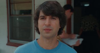 Movie still from “Taking Woodstock” (2009), directed by Ang Lee – A person wearing a blue t - shirt; Close Up shot, Over the shoulder angle