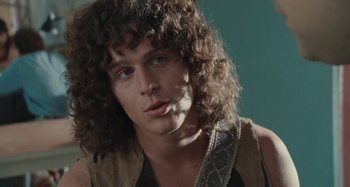 Movie still from “Taking Woodstock” (2009), directed by Ang Lee – A man with long curly hair is smoking a cigarette; Close Up shot, Low angle