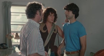 Movie still from “Taking Woodstock” (2009), directed by Ang Lee – A group of men standing next to each other in a room; Medium shot, Over the shoulder angle