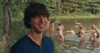 Movie still from “Taking Woodstock” (2009), directed by Ang Lee – A man standing in a body of water with people swimming; Medium shot, Over the shoulder angle