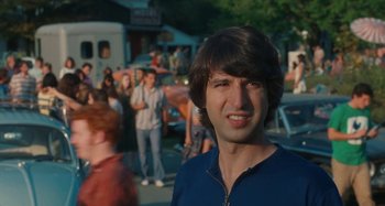Movie still from “Taking Woodstock” (2009), directed by Ang Lee – A man standing in front of a group of people; Close Up shot, Over the shoulder angle