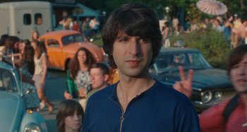 A man in a blue shirt is in front of a group of people