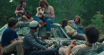 Movie still from “Taking Woodstock” (2009), directed by Ang Lee – A group of people sitting on top of a car; Wide shot, High angle