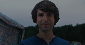 A man in a blue shirt is smiling for the camera