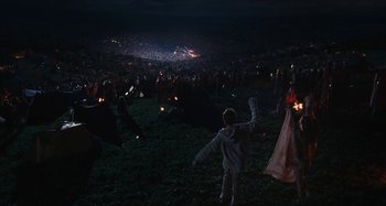 Movie still from “Taking Woodstock” (2009), directed by Ang Lee – A group of people standing in a field at night; Extreme Wide shot, High angle