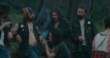 Movie still from “Taking Woodstock” (2009), directed by Ang Lee – A group of men standing next to each other smoking; Medium shot, Over the shoulder angle