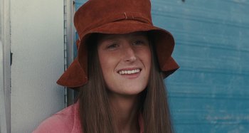 Movie still from “Taking Woodstock” (2009), directed by Ang Lee – A woman with long brown hair wearing a brown hat; Close Up shot, High angle