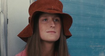 Movie still from “Taking Woodstock” (2009), directed by Ang Lee – A woman with long brown hair wearing a brown hat; Close Up shot, High angle
