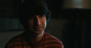 A young man is smiling for the camera