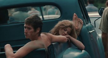 Movie still from “Taking Woodstock” (2009), directed by Ang Lee – A man and a woman in the back seat of a car; Medium shot, High angle