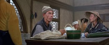 A man sitting at a table in front of a bowl of food