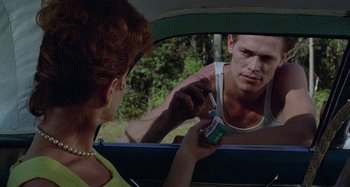 Movie still from “The Loveless” (1981), directed by Kathryn Bigelow – A woman is looking at a man in the mirror; Medium shot, Over the shoulder angle