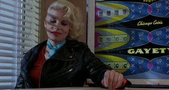 Movie still from “The Loveless” (1981), directed by Kathryn Bigelow – A woman sitting at a counter with a pen in her hand; Close Up shot, Over the shoulder angle