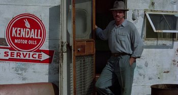 Movie still from “The Loveless” (1981), directed by Kathryn Bigelow – A man standing in front of an open door; Wide shot, Low angle