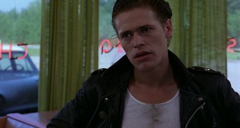 Movie still from “The Loveless” (1981), directed by Kathryn Bigelow – A young man in a white shirt and a black jacket; Close Up shot, Low angle