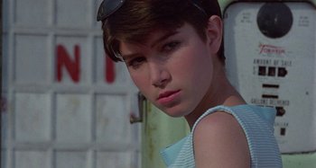Movie still from “The Loveless” (1981), directed by Kathryn Bigelow – A young woman wearing a blue and white striped top; Close Up shot, Low angle