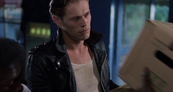 Movie still from “The Loveless” (1981), directed by Kathryn Bigelow – A man wearing a black leather jacket looking down; Close Up shot, Over the shoulder angle
