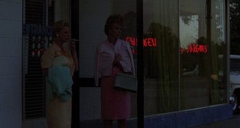 Movie still from “The Loveless” (1981), directed by Kathryn Bigelow – Two women standing in front of a store window; Wide shot, Low angle