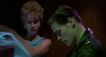 Movie still from “The Loveless” (1981), directed by Kathryn Bigelow – A man and a woman standing next to each other; Close Up shot, Over the shoulder angle