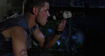 Movie still from “The Loveless” (1981), directed by Kathryn Bigelow – A man is drinking a beer from a bottle; Close Up shot, High angle
