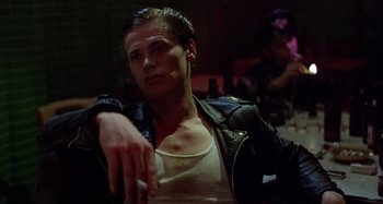 Movie still from “The Loveless” (1981), directed by Kathryn Bigelow – A man in a black leather jacket smoking a cigarette; Close Up shot, Low angle